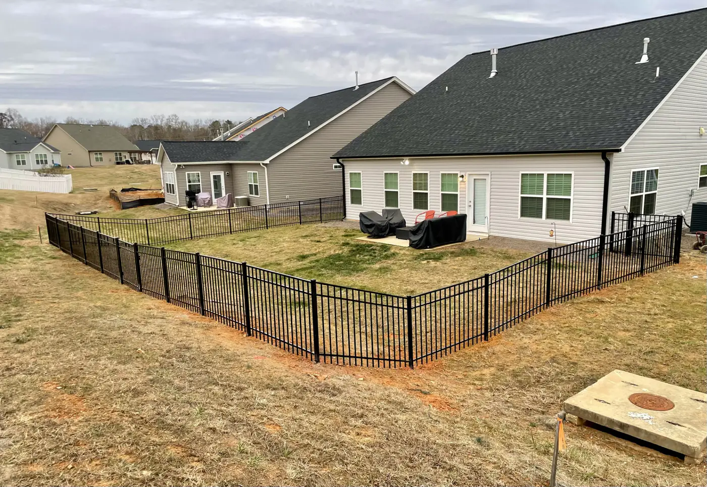 Black aluminum fence enclosing the backyard of a ranch-style home near Graham, NC