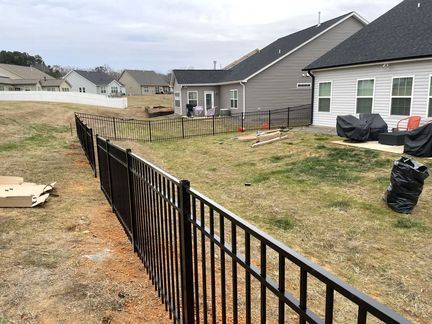 Long run of black aluminum fence at a newly built home