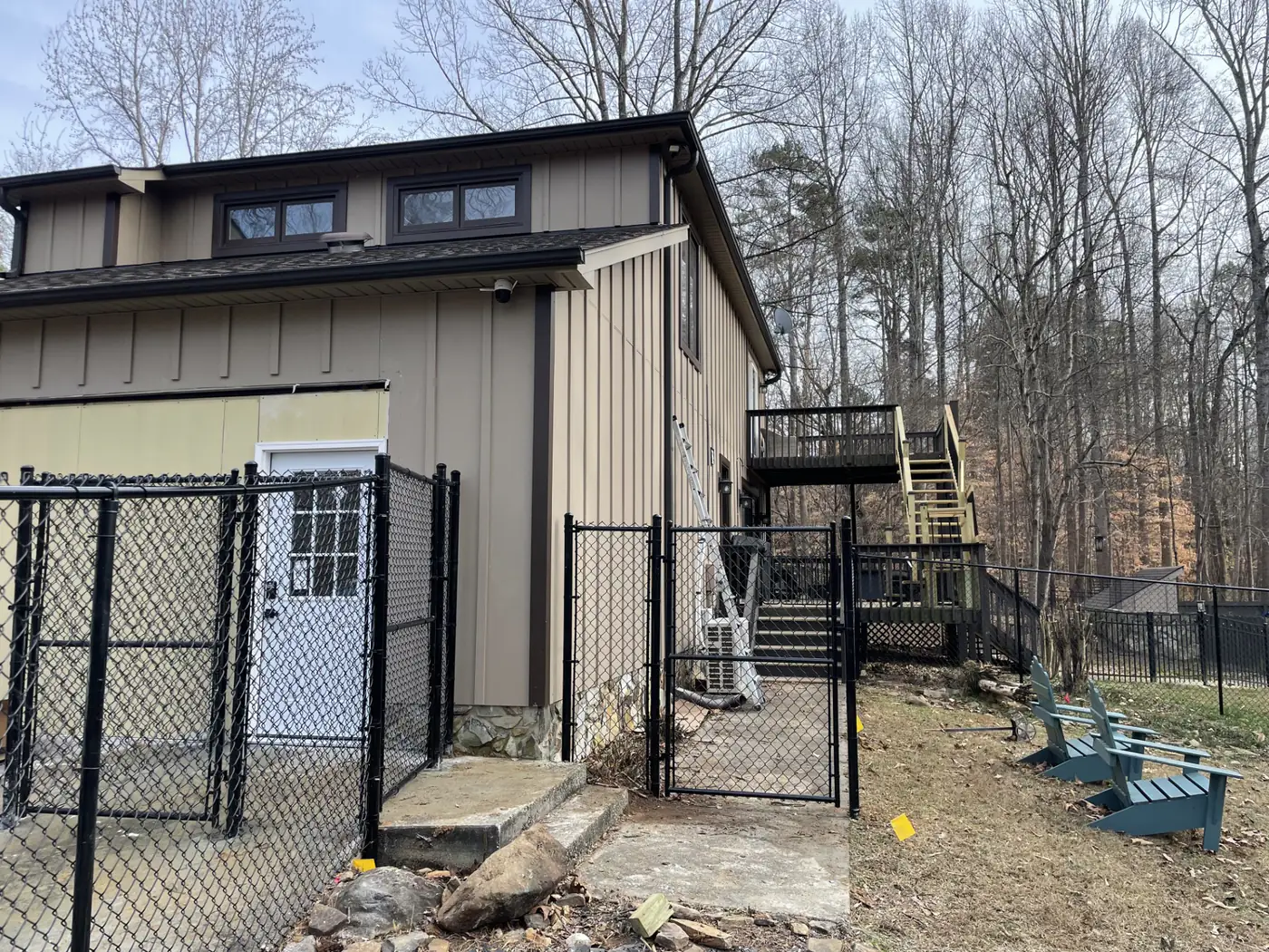 Chain link fence and gate securing an outbuilding and exterior stairs