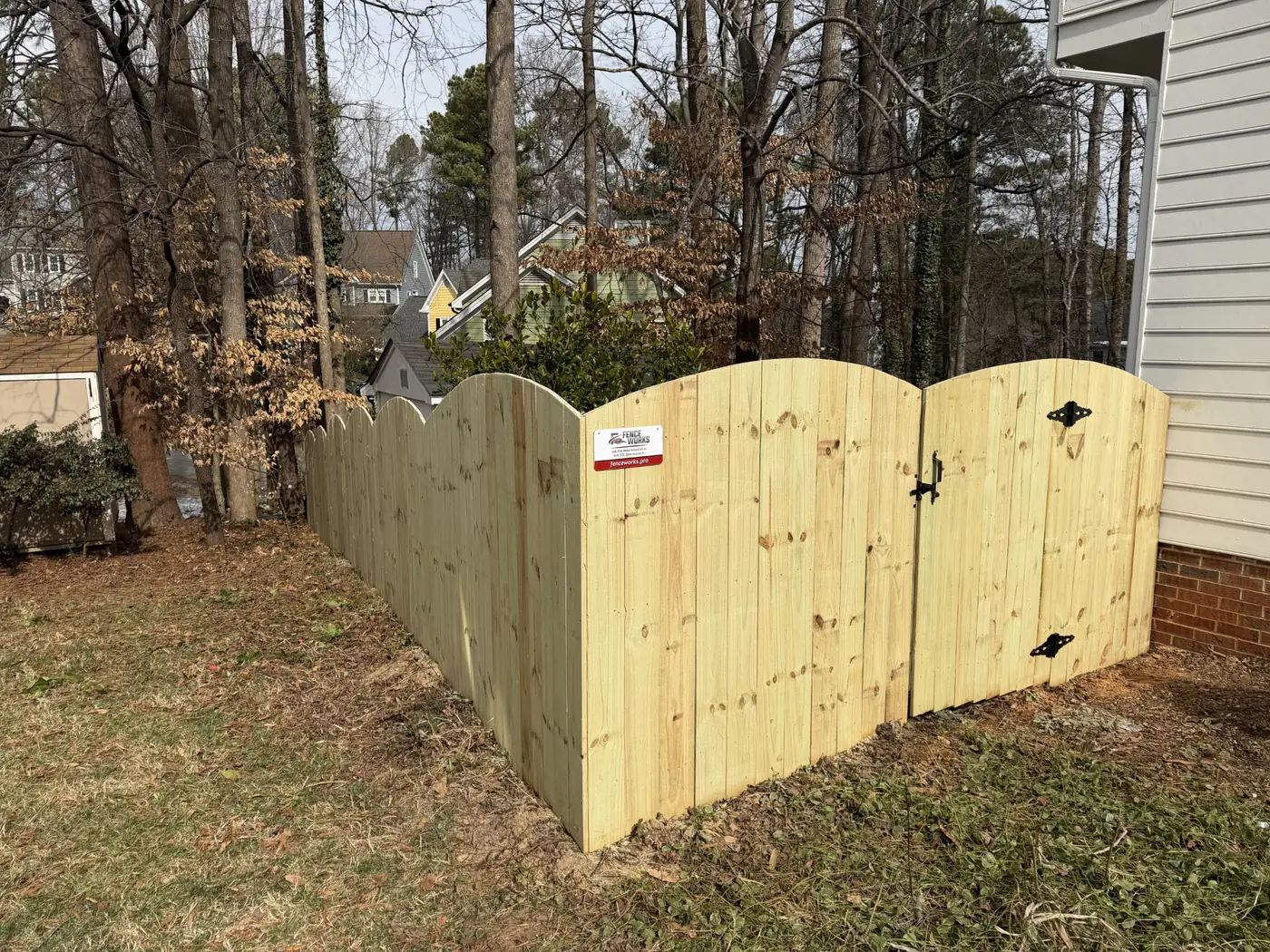 Arched-top wood privacy fence with a matching double gate