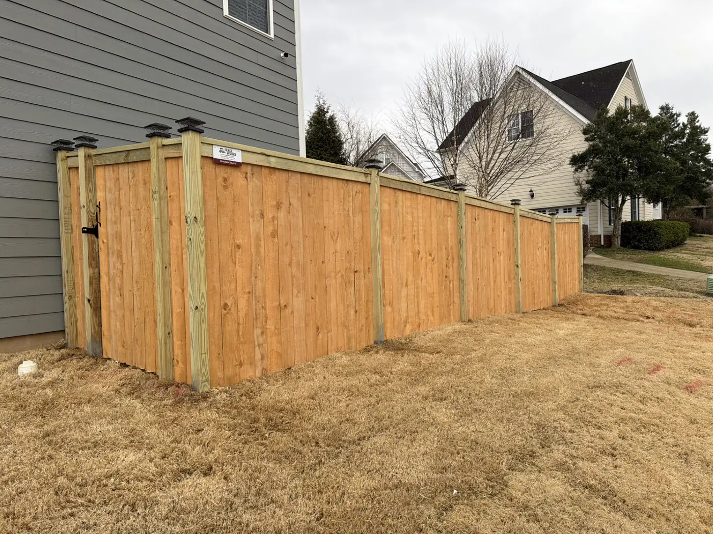 Cap-and-trim wood privacy fence with a walk gate rebuilt in a Graham side yard