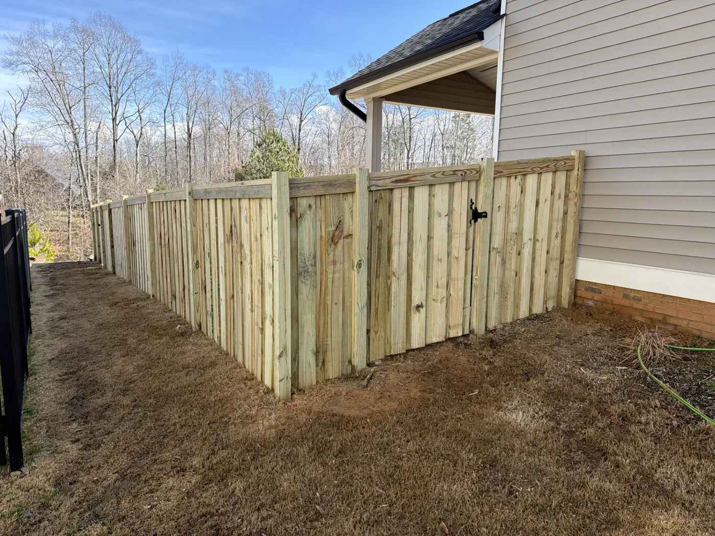 Replacement wood privacy fence and gate rebuilt beside a Graham home