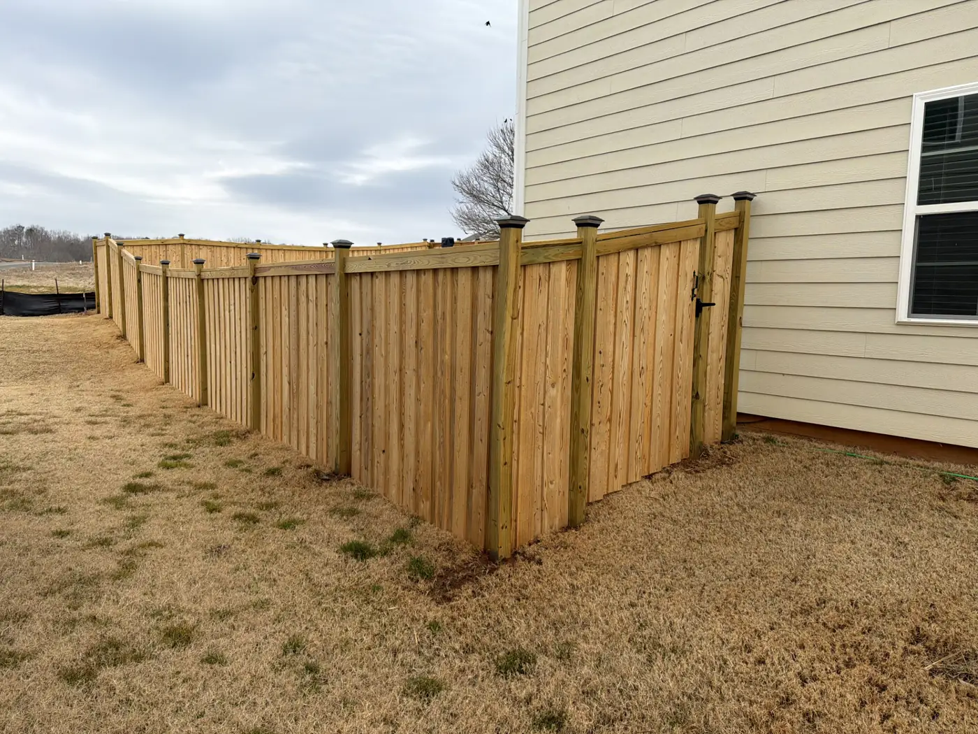 Wood privacy fence stepped along a graded Graham backyard with a finished cap rail
